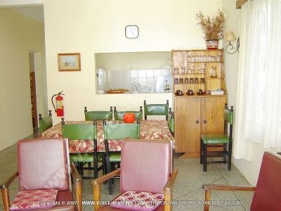 apartment abel mauritius living room view
Abel Apartment view of the living room, the dining room and the kitchen. The kitchen is equipped with a fridge and a kettle. It looks onto the dining room which has a dining table, chairs, a glass cupboard. The dining room leads to the living room. 
Keywords: Abel Apartment, living room, dining room, kitchen, chairs, table,
