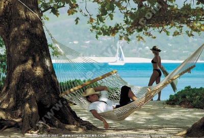 sainte anne resort seychelles guest relaxing in hammock

